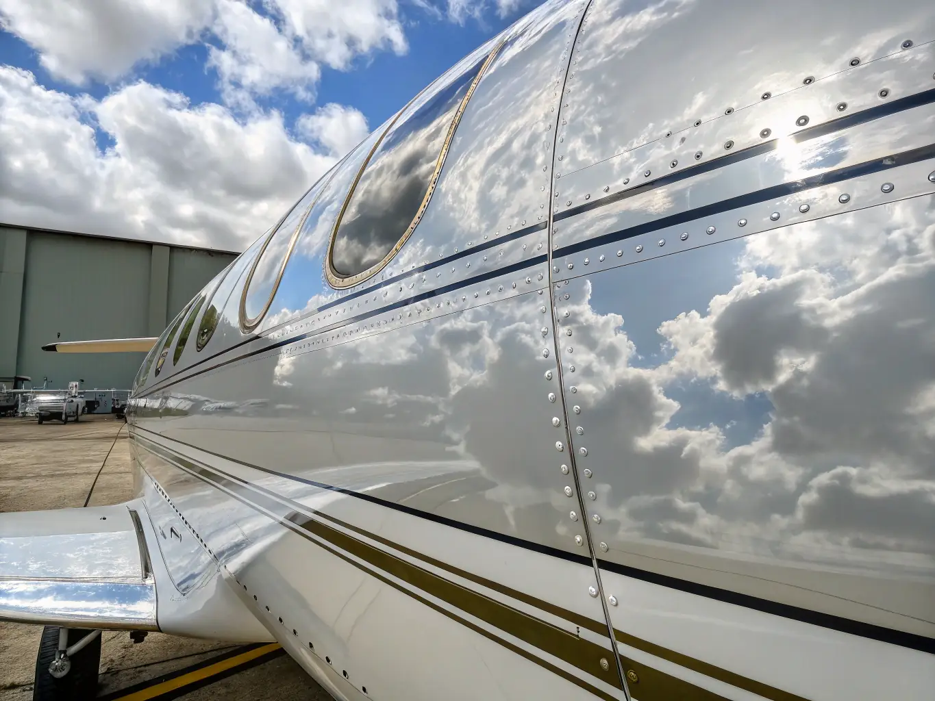 A close-up image of a sleek aircraft wing coated with a shiny, reflective ceramic layer, highlighting the smooth finish and gloss. The image should convey the high-quality finish achieved with System X Max G+.